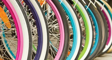 close up of many brightly coloured bicycle wheels
