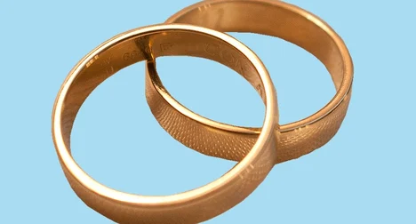 Two gold rings against a bright blue background.
