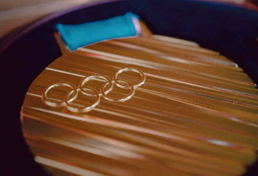 a close up of a gold olympic medal with the five rings