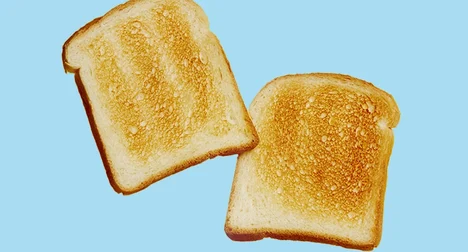 two slices of white toast in mid air on a blue background