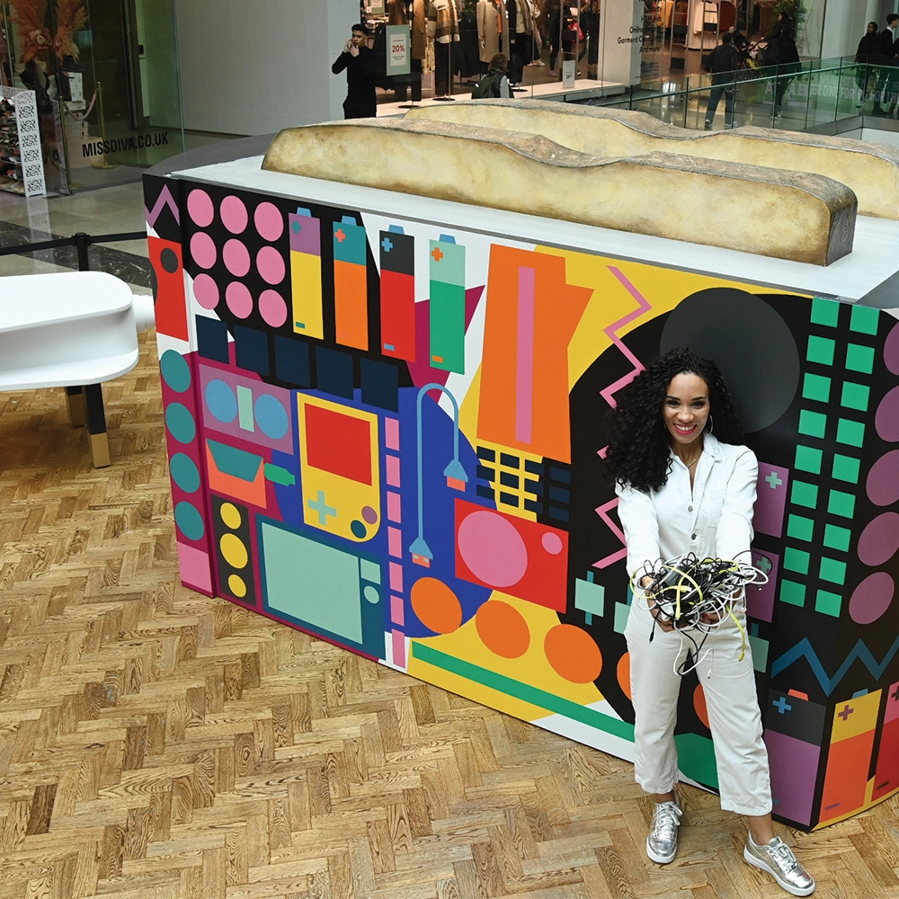 dark skinned presenter Michelle Ackerley in front of giant toaster in a shopping centre