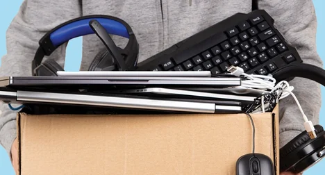 man with light grey top and pale hands holding box of electricals for recycling