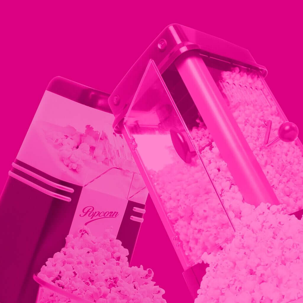 Floating vintage style popcorn makers in a pink haze against a bright pink backdrop