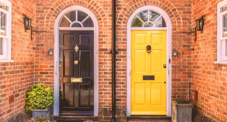 two residential front doors side by side - one black and one yellow