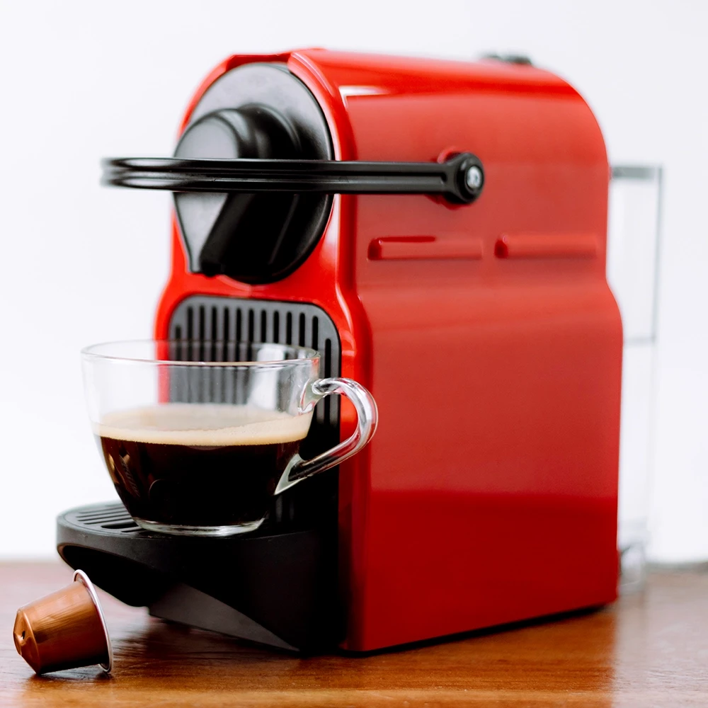 Coffee-Machine V2 1000 px red domestic coffee machine with pods and half full glass coffee cup